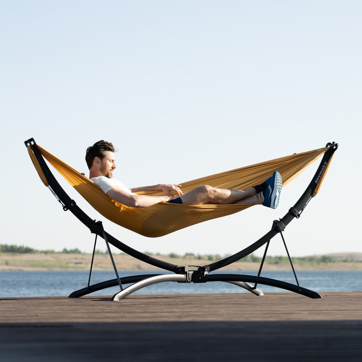 Hamaca anymaka con soporte instalada sobre un deck de madera junto al agua